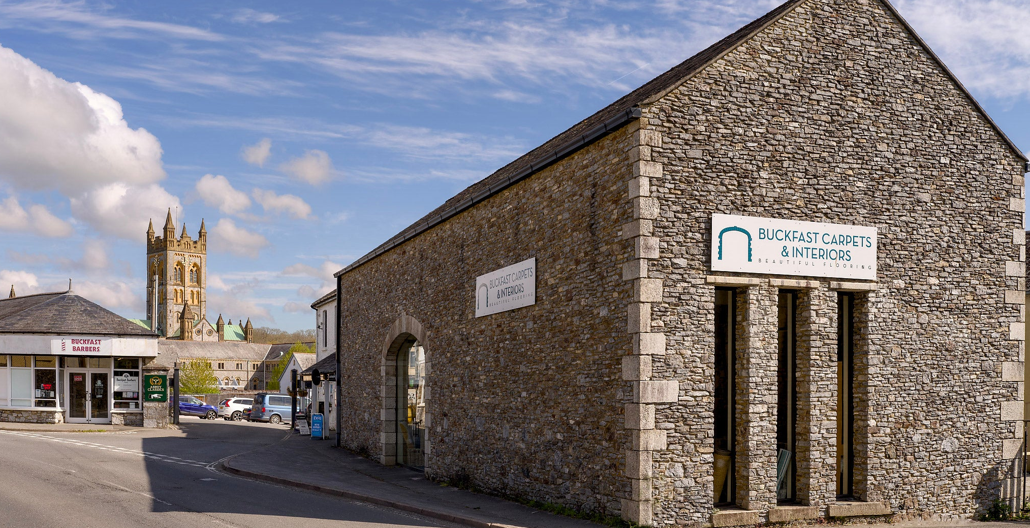 The exterior of Buckfast Carpets with Buckfast abbey in the Background