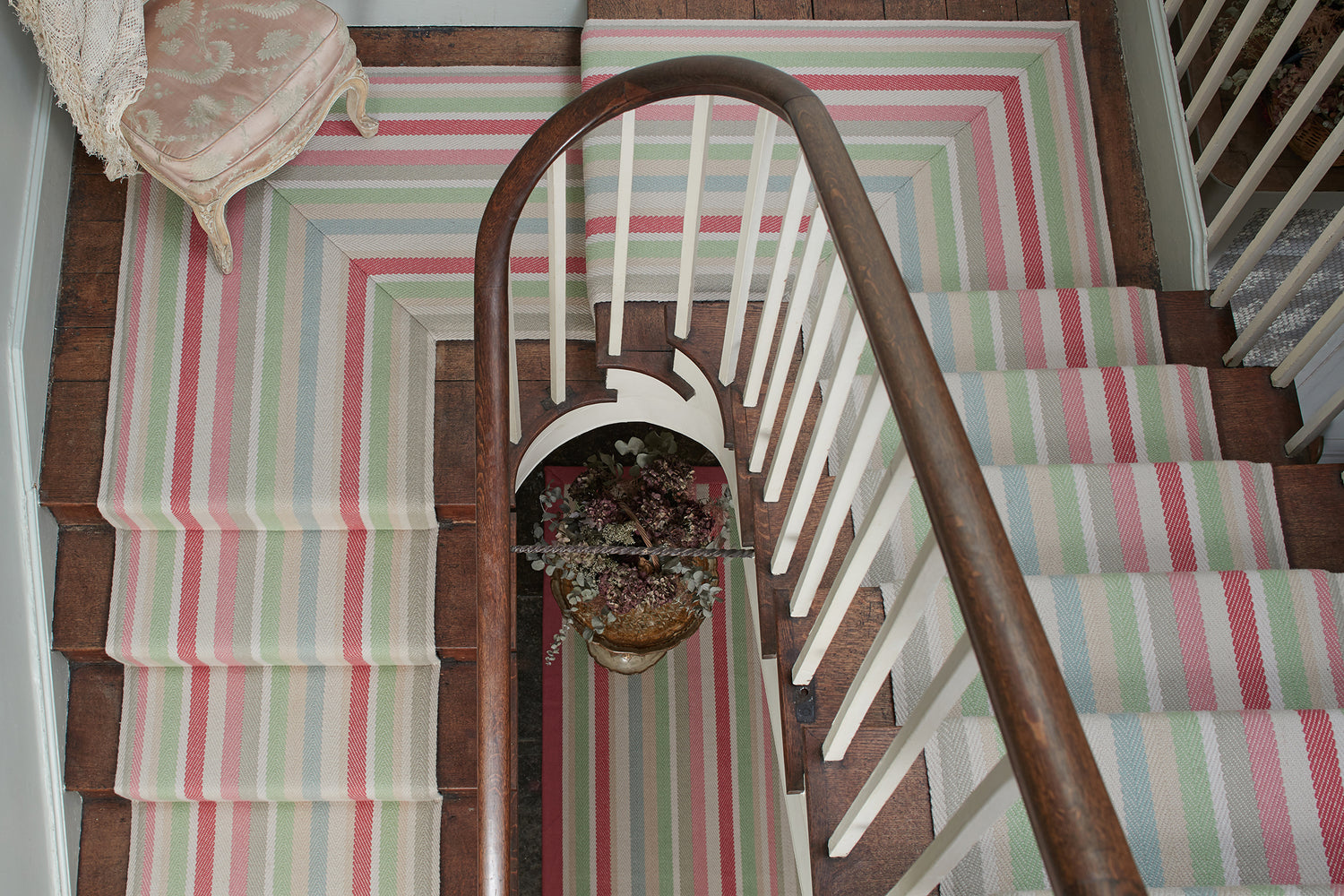 Colourful striped stair runner by Roger Oates fitted to a wooden staircase